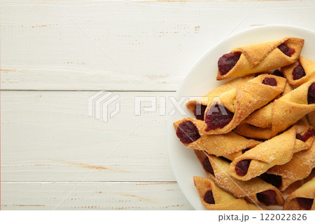 Tasty bagels with strawberry jam on white wooden background. Homemade cookies 122022826