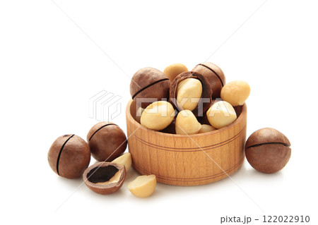 Peeled macadamia nuts in wooden bowl isolated on white background. 122022910