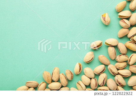 Pile of Pistachios on the green background with copy space. 122022922