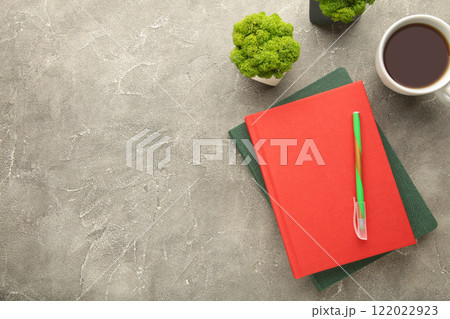 Red notebook with coffee cup and pencil on grey background. Flat lay, creative workspace office. Business-education concept with copy space. Red notebook with coffee cup and pencil on grey background. Flat lay, creative workspace office. Business-education concept with copy space. 122022923