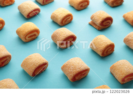 Homemade cookies, mini rolls with apricot jam on blue background. Top view 122023026