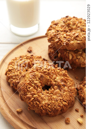 Peanut cookies on cutting board with milk on white wooden background. Vertical photo. Peanut cookies on cutting board with milk on white wooden background. Vertical photo. 122023029
