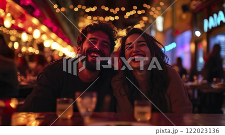 Man and woman sitting together at a table in a casual indoor setting Man and woman sitting together at a table in a casual indoor setting 122023136