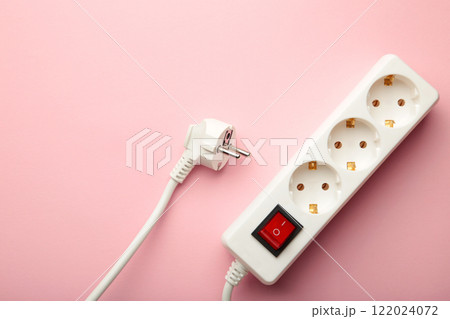 Electric white portable socket on pink background Electric white portable socket on pink background 122024072