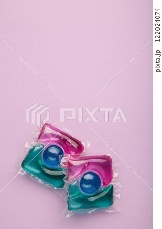 Washing powder in capsules on a purple background. Vertical photo. Washing powder in capsules on a purple background. Vertical photo. 122024074