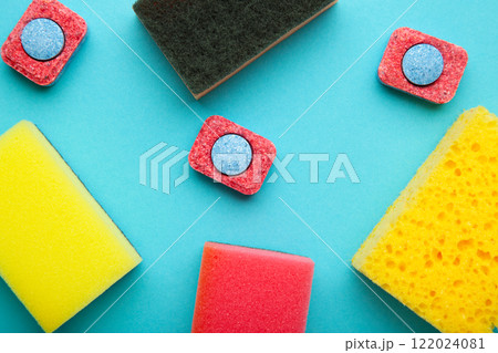 Dishwasher tablets on a dishwashing sponges on a blue background, dishwashing products Dishwasher tablets on a dishwashing sponges on a blue background, dishwashing products 122024081