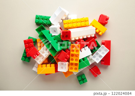 Multicolored blocks of the children's constructor lie on grey background. Multicolored blocks of the children's constructor lie on grey background. 122024084