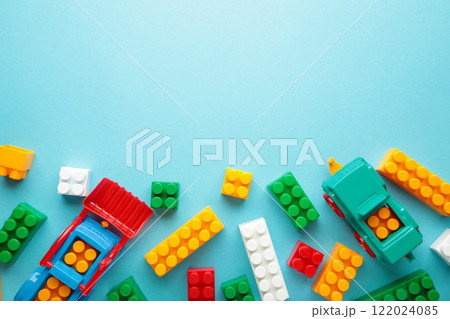 Multicolored blocks of the children's constructor lie on blue background. Multicolored blocks of the children's constructor lie on blue background. 122024085