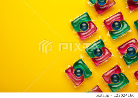 Washing powder in capsules on a yellow background. Washing powder in capsules on a yellow background. 122024160