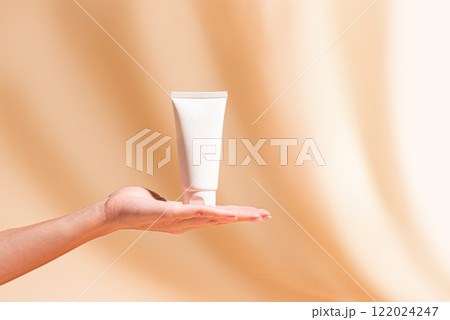 Woman hand hold white cosmetic cream tube Woman hand hold white cosmetic cream tube 122024247