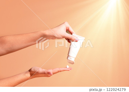 Female hands hold and apply cosmetic moisturizer cream 122024279
