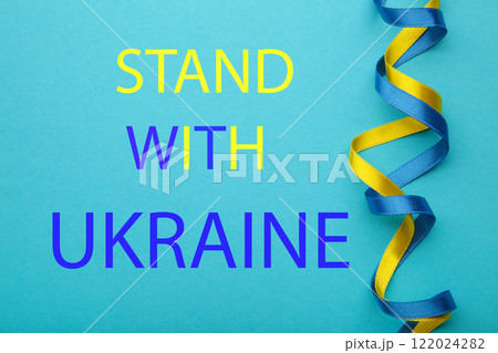 Inscription Stand with Ukraine on blue background. Conflict between Ukraine and Russia. No war, stop war, russian aggression. Ukrainian patriot. Inscription Stand with Ukraine on blue background. Conflict between Ukraine and Russia. No war, stop war, russian aggression. Ukrainian patriot. 122024282