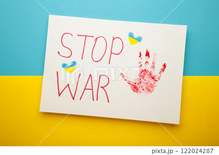 Inscription Stop war with baby handprint on blue - yellow background, conflict between Ukraine and Russia. No war, stop war, russian aggression. Ukrainian patriot. 122024287