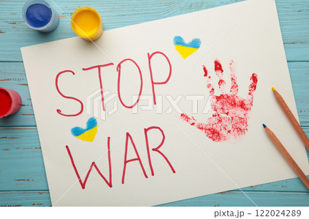 Inscription Stop war with baby handprint on blue background, conflict between Ukraine and Russia. No war, stop war, russian aggression. Ukrainian patriot. Inscription Stop war with baby handprint on blue background, conflict between Ukraine and Russia. No war, stop war, russian aggression. Ukrainian patriot. 122024289