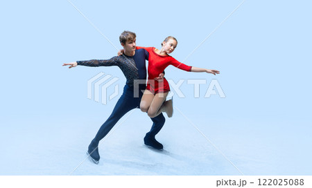 Professional ice skating partners perform difficult lift, show their elegance against cold blue background. Artistic ice dance. 122025088