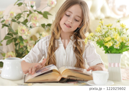 Close up portrait of young girl reading interesting big book 122025602