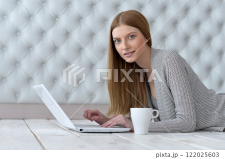 Portrait of a happy young girl with laptop computer 122025603
