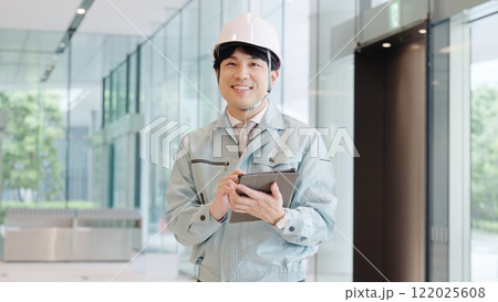 笑顔で働く作業服を着た男性 122025608