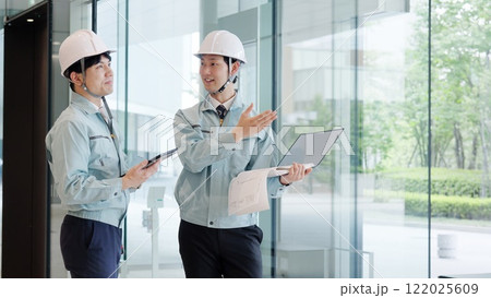 打ち合わせをする作業服を着た男性 122025609
