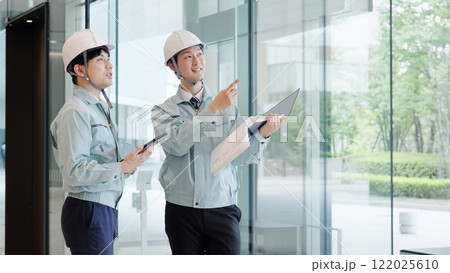 打ち合わせをする作業服を着た男性 打ち合わせをする作業服を着た男性 122025610