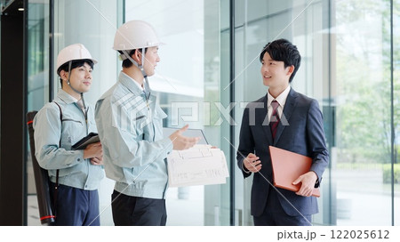 クライアントと打ち合わせをする作業服を着た男性 122025612