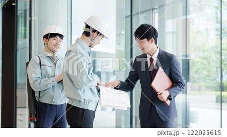 クライアントと打ち合わせをする作業服を着た男性 122025615