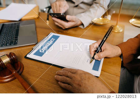 Teamwork of business lawyer meeting working hard about legal legislation in courtroom to help their customer. Teamwork of business lawyer meeting working hard about legal legislation in courtroom to help their customer. 122028013