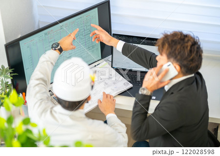 工事工程表を説明する男性主任技術者　ネットワーク工程表　工事監理　ヘルメット　2人 122028598