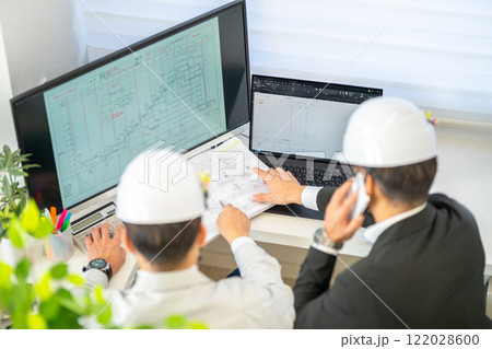 工事工程表を説明する男性主任技術者　ネットワーク工程表　工事監理　ヘルメット　2人 122028600