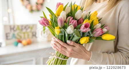 A woman is gently holding a beautiful bouquet of flowers in her hands A woman is gently holding a beautiful bouquet of flowers in her hands 122028673