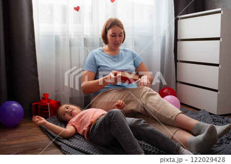 Caucasian woman speech therapist teaches a girl to pronounce sounds correctly. A woman and a child are reading a book together. The concept of preschool education 122029428