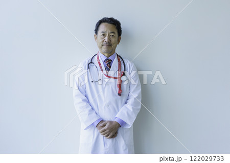 白背景のミドルエイジの医師のポートレート　撮影協力：学校法人電波学園 東京電子專門学校 122029733