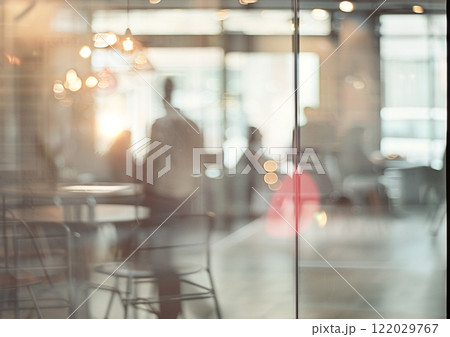 Blurred images of an office and unrecognizable people behind the glass. 122029767
