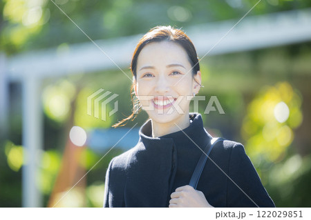 歩道を歩くコートの女性 122029851