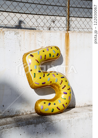 5-number-shaped balloon against a wall 122030067