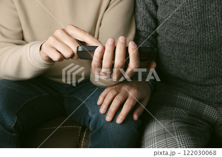man shows something in his smartphone to his partner 122030068