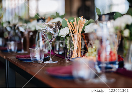 Luxurious dining table setup with flowers, appetizers, and wine glasses for an elegant celebration 122031361