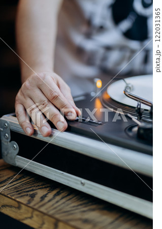 DJ adjusting turntable settings, capturing the artistry of live music mixing and performance 122031365
