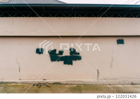 Vandalism with spray paint on the wall of a house. damaged surface with black paint 122031426