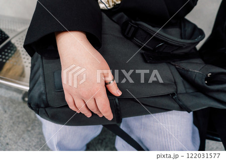 girl's hand lies on backpack. protection from theft of things in a backpack girl's hand lies on backpack. protection from theft of things in a backpack 122031577