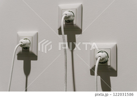 white electrical sockets with plugs in them. connecting high-voltage wire to the socket 122031586
