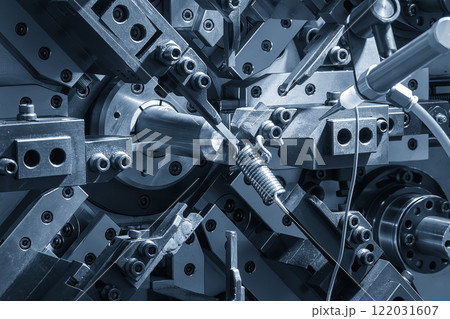 Close up scene operation of the coil spring making machine in the light blue scene. Close up scene operation of the coil spring making machine in the light blue scene. 122031607