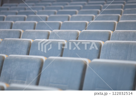 A row of empty blue chairs in the auditorium. 122032514