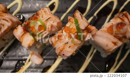 Salmon Oyako Spicy roll consist of crispy salmon skin is wrapped with sushi rice, topped with half broiled Aburi Salmon with spicy sauce Salmon Oyako Spicy roll consist of crispy salmon skin is wrapped with sushi rice, topped with half broiled Aburi Salmon with spicy sauce 122034107