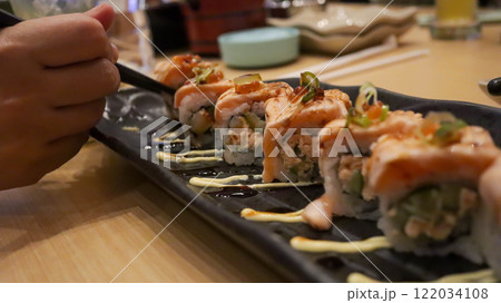 Salmon Oyako Spicy roll consist of crispy salmon skin is wrapped with sushi rice, topped with half broiled Aburi Salmon with spicy sauce Salmon Oyako Spicy roll consist of crispy salmon skin is wrapped with sushi rice, topped with half broiled Aburi Salmon with spicy sauce 122034108