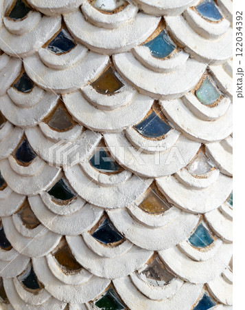 Traditional Thai Stucco Serpent-Scale Pattern with Glass Accents. Traditional Thai Stucco Serpent-Scale Pattern with Glass Accents. 122034392