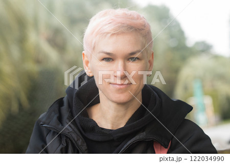 Attractive middle-aged woman with short hair and a black jacket outdoors 122034990