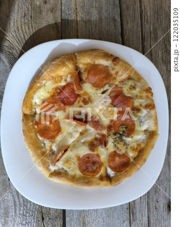 delicious slice of pizza lies on the table on a sliced board. delicious slice of pizza lies on the table on a sliced board. 122035109