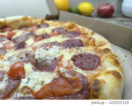 delicious slice of pizza lies on a sliced board, with glasses of beer in th.. delicious slice of pizza lies on a sliced board, with glasses of beer in th.. 122035119