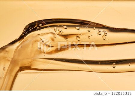 Tasty texture of cosmetic gel on a golden background. Tasty texture of cosmetic gel on a golden background. 122035315